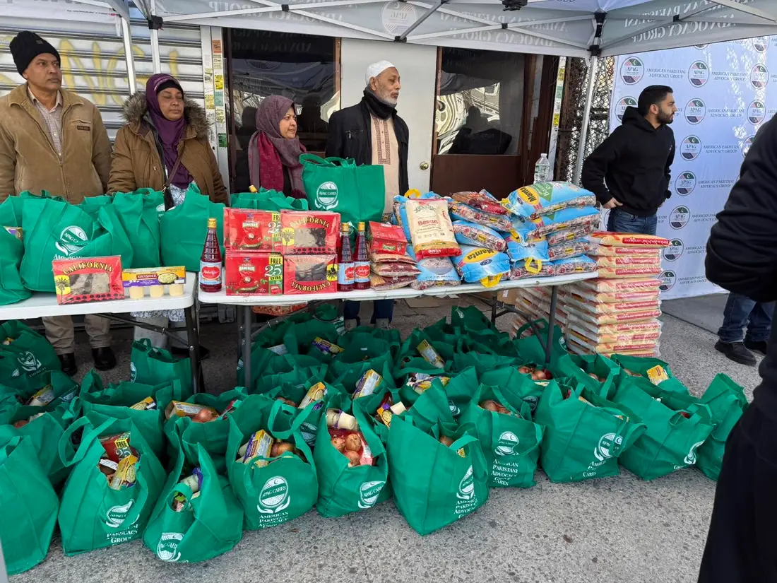 Tables filled with APAG Cares food bags and pantry staples during a community food drive
